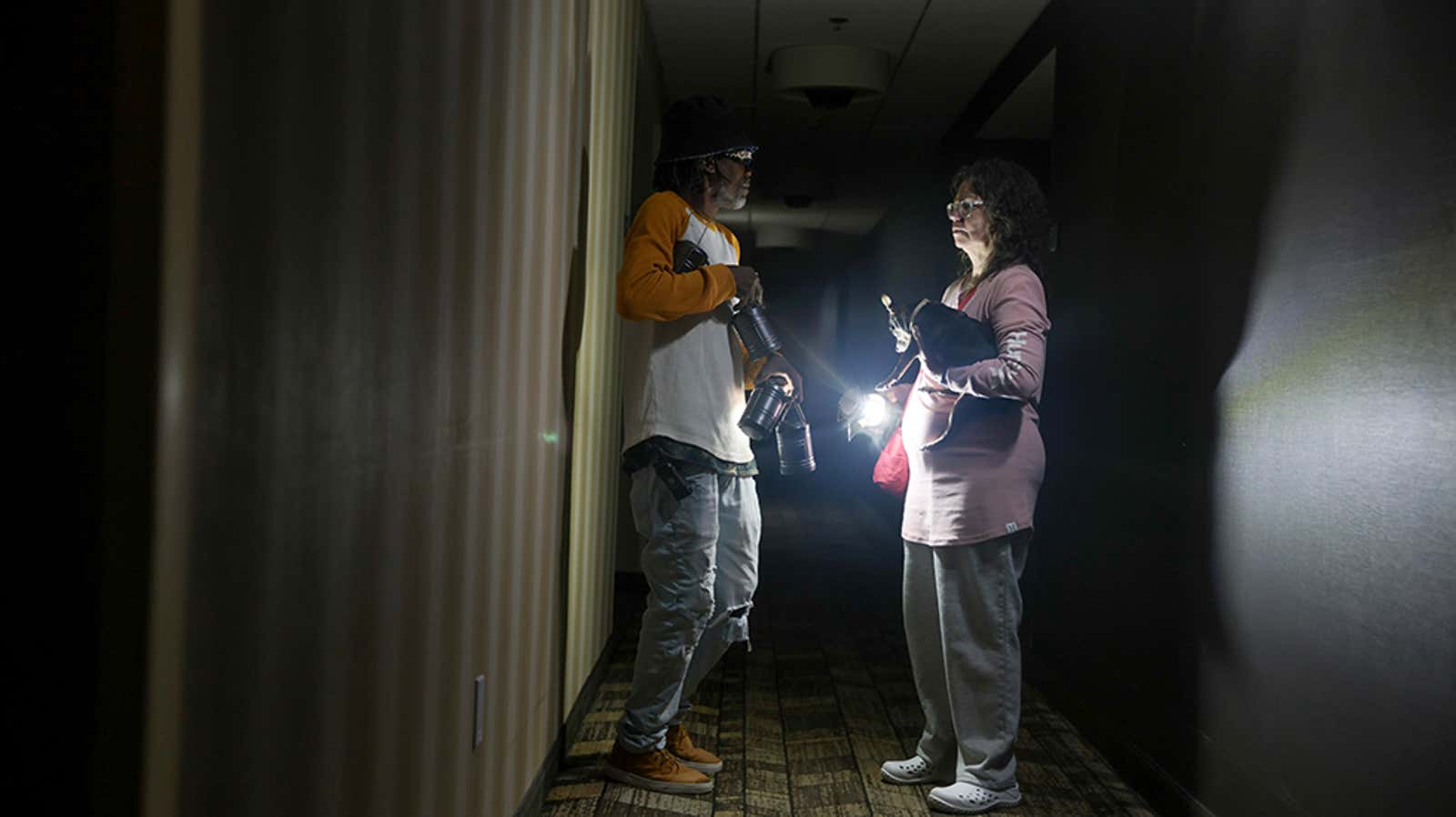 Guests navigate a dark motel hallway in Pensacola during the Isaias power outage