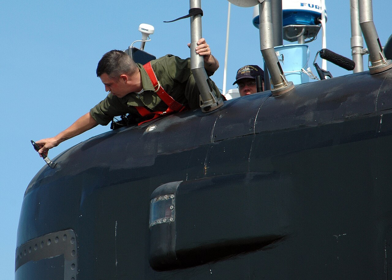 A U.S. Navy sailor paints the sail of the Virginia-class fast-attack submarine USS North Carolina